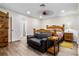 Cozy bedroom featuring wood-look tile flooring, a rustic wooden bed frame, and a comfortable leather loveseat at 37224 Apiary Rd, Grand Island, FL 32735