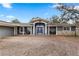 Inviting home exterior featuring a bright blue front door, stone accents, and a covered porch with seating at 37224 Apiary Rd, Grand Island, FL 32735