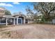 Attractive front exterior with a blue door, inviting porch seating, and mature landscaping at 37224 Apiary Rd, Grand Island, FL 32735