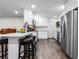 Modern white kitchen with stainless steel appliances, a breakfast bar, and wood-look floors at 37224 Apiary Rd, Grand Island, FL 32735