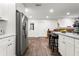 Bright kitchen with stainless steel appliances, white cabinets, island with barstool seating, and a decorative brick fireplace at 37224 Apiary Rd, Grand Island, FL 32735