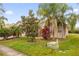 A tan single-story home with lush landscaping and palm trees creates a serene curb appeal at 3927 Port Sea Pl, Kissimmee, FL 34746