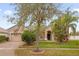 Inviting single-story home with a lush green lawn, mature trees, and a welcoming front entrance at 3927 Port Sea Pl, Kissimmee, FL 34746