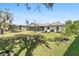 A spacious backyard with a lawn, mature trees, trampoline, and outdoor seating area, perfect for entertaining and relaxation at 4100 Cannon Ct, Kissimmee, FL 34746