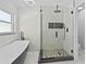Stylishly renovated bathroom featuring a glass-enclosed shower, freestanding tub, and sleek black hardware accents at 4100 Cannon Ct, Kissimmee, FL 34746