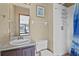 Standard bathroom featuring a single sink vanity, toilet, and tiled shower with blue curtain at 4100 Cannon Ct, Kissimmee, FL 34746