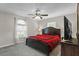 Bedroom with ceiling fan, window, and a dark wood bed dressed with red and black bedding at 4100 Cannon Ct, Kissimmee, FL 34746