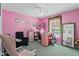 Bright bedroom featuring pink walls, a ceiling fan, and a professional nail salon setup at 4100 Cannon Ct, Kissimmee, FL 34746
