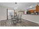 Charming dining area with gray laminate flooring and a glass-top table under a modern light fixture at 4100 Cannon Ct, Kissimmee, FL 34746