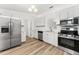 Bright kitchen showcasing stainless steel appliances, white cabinets, and wood grain floors at 4135 Iveyglen Ave, Orlando, FL 32826