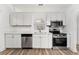 White kitchen with modern stainless steel appliances, bright white cabinets, and sleek countertops at 4135 Iveyglen Ave, Orlando, FL 32826