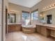 Bright bathroom showcasing a soaking tub, tile flooring, and double vanity sinks with elegant countertops at 418 Laurenburg Ln, Ocoee, FL 34761