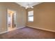 Neutral carpeted bedroom with en suite bathroom, window and ceiling fan at 418 Laurenburg Ln, Ocoee, FL 34761