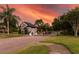 Gated community entrance with beautiful landscaping, palm trees, and dusk sky at 418 Laurenburg Ln, Ocoee, FL 34761