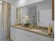 Modern bathroom featuring a granite countertop with dual sinks, white cabinetry, and decorative accents at 4253 Singing Mockingbird Blvd, Bartow, FL 33830