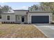 Charming single-story home with gray stucco exterior, a well-manicured lawn, and a two-car garage at 4405 Sw 155Th Place Rd, Ocala, FL 34473