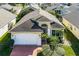 Overhead view of a house featuring a brick driveway, a two-car garage, and beautiful landscaping at 53 High Vista Dr, Davenport, FL 33837