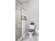 Well-lit bathroom with glass-enclosed shower and decorated toilet and tiled flooring at 53 High Vista Dr, Davenport, FL 33837