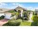 Well-landscaped home featuring a brick driveway, a two-car garage, and a red front door at 53 High Vista Dr, Davenport, FL 33837