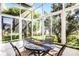 Bright, enclosed sunroom with garden views and outdoor seating at 53 High Vista Dr, Davenport, FL 33837