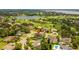 Aerial view of a luxurious home with pool surrounded by manicured lawns, a golf course, and a scenic lake at 5447 Brookline Dr, Orlando, FL 32819