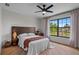 Bright bedroom featuring hardwood floors, modern furniture, and a large window overlooking a lush front yard at 5447 Brookline Dr, Orlando, FL 32819