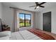 Well-lit bedroom featuring hardwood floors, modern furniture, and a large window with a view of the backyard at 5447 Brookline Dr, Orlando, FL 32819