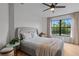 Bright bedroom with gray upholstered bed, large window with backyard view, and neutral decor at 5447 Brookline Dr, Orlando, FL 32819