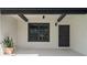 Inviting covered entrance featuring sleek black accents, a modern light fixture, and a decorative potted plant at 5447 Brookline Dr, Orlando, FL 32819