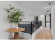 Well-lit hallway featuring hardwood floors, black railings, and a decorative plant on a round table at 5447 Brookline Dr, Orlando, FL 32819