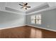 Bedroom with tray ceiling, ceiling fan, and wood-look flooring at 706 Westpark Way # 203, Celebration, FL 34747