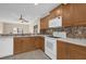 Bright kitchen featuring wood cabinets, granite countertops, and modern appliances at 706 Westpark Way # 203, Celebration, FL 34747