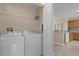 Well-equipped laundry area with washer, dryer, and convenient storage shelving at 706 Westpark Way # 203, Celebration, FL 34747