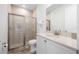 Well-lit bathroom with a glass shower, a modern sink with quartz counters and a large mirror at 8179 Coconut Pl, Kissimmee, FL 34747