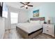 Inviting bedroom featuring a wood-frame bed, matching nightstands, soft lighting, and a soothing blue accent wall at 8179 Coconut Pl, Kissimmee, FL 34747