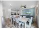 Open-concept dining area featuring a table with seating adjacent to the modern kitchen and a living space with a blue accent wall at 8179 Coconut Pl, Kissimmee, FL 34747