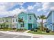 Street view of colorful modern townhomes with tropical landscaping at 8179 Coconut Pl, Kissimmee, FL 34747