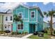 Exterior of a two-story townhome, with light teal facade, walkway and landscaping at 8179 Coconut Pl, Kissimmee, FL 34747