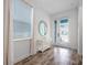 Bright foyer with wood-look tile flooring and table below a round mirror at 8179 Coconut Pl, Kissimmee, FL 34747