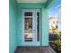 Close up of the entrance of a teal home with a glass door at 8179 Coconut Pl, Kissimmee, FL 34747