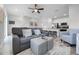 Inviting living room with a comfortable gray sofa, striped ottoman, and easy access to a modern kitchen with bar seating at 8179 Coconut Pl, Kissimmee, FL 34747