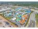 Aerial view of a sprawling water park with colorful slides, lazy rivers, pools, and lush landscaping at 8179 Coconut Pl, Kissimmee, FL 34747