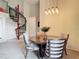 Dining room with modern light fixture above a round table and four chairs, adjacent to a spiral staircase at 114 Vista Verdi Cir # 328, Lake Mary, FL 32746