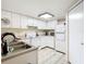 Functional kitchen featuring white cabinets and appliances, and a light-colored floor at 114 Vista Verdi Cir # 328, Lake Mary, FL 32746