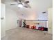 Upper loft area with carpeting, ceiling fan, and railing overlooking the downstairs area at 114 Vista Verdi Cir # 328, Lake Mary, FL 32746