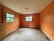 Empty bedroom features two windows offering natural light in need of refurbishment at 115 S Lake Pleasant Rd, Apopka, FL 32703