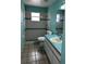 Cozy bathroom featuring neutral tile and blue accent stripe in the shower and walls at 121 Loma Bonita Dr, Davenport, FL 33837