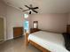 Cozy bedroom with tile floors, ceiling fan, and view into the bright, blue bathroom at 121 Loma Bonita Dr, Davenport, FL 33837