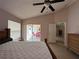Bedroom features a ceiling fan, neutral colors, and a sliding glass door leading to a patio at 121 Loma Bonita Dr, Davenport, FL 33837
