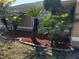 Front yard with lush landscaping, including mulch beds, palms and yellow flowering bushes at 121 Loma Bonita Dr, Davenport, FL 33837